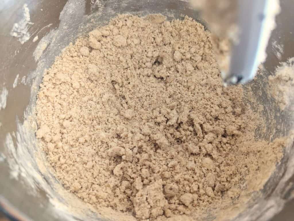 Image show butter, flour, and brown sugar in a food processor for the shortbread base.