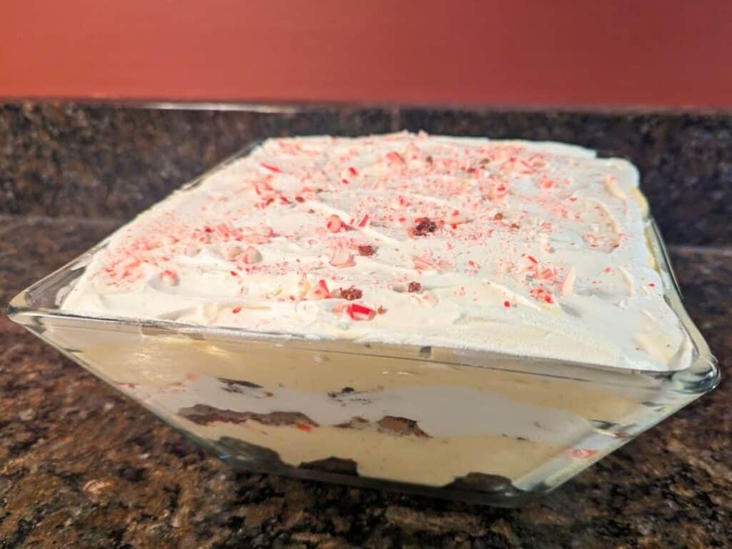 Image shows side view of a layered brownie peppermint trifle in a glass dish.