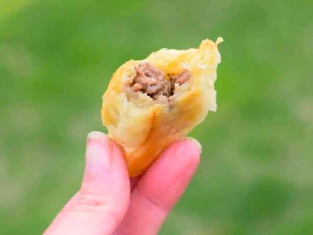 Image shows delicious puff pastry beef empanada.
