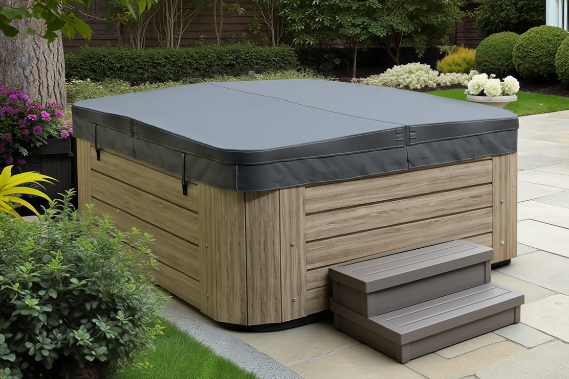 Gray hot tub cover on a wooden outdoor spa in a lush garden near a modern house.