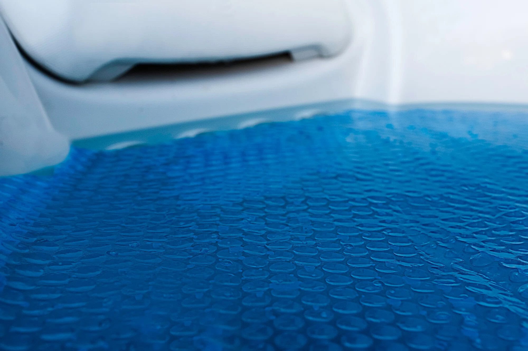Close-up of hot tub solar blanket on water inside hot tub, featuring bubble wrap design for insulation
