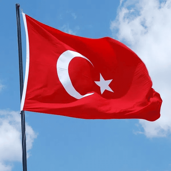 Turkey flag flying outdoors with a blue sky background, symbolizing national pride and culture, relevant for Houston EB5 investment opportunities in Turkey.