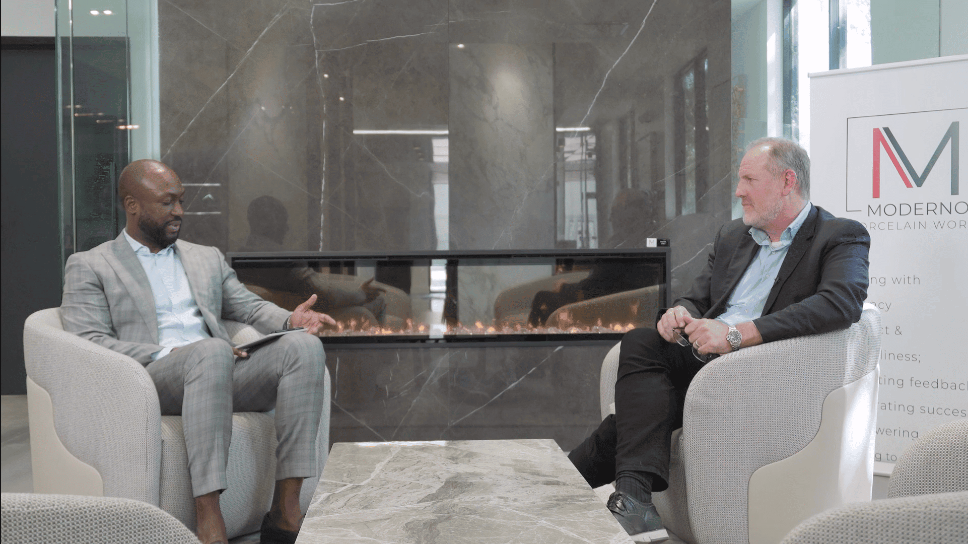 High-quality image of two businessmen having a discussion at a Houston EB5 investment conference in modern corporate office.