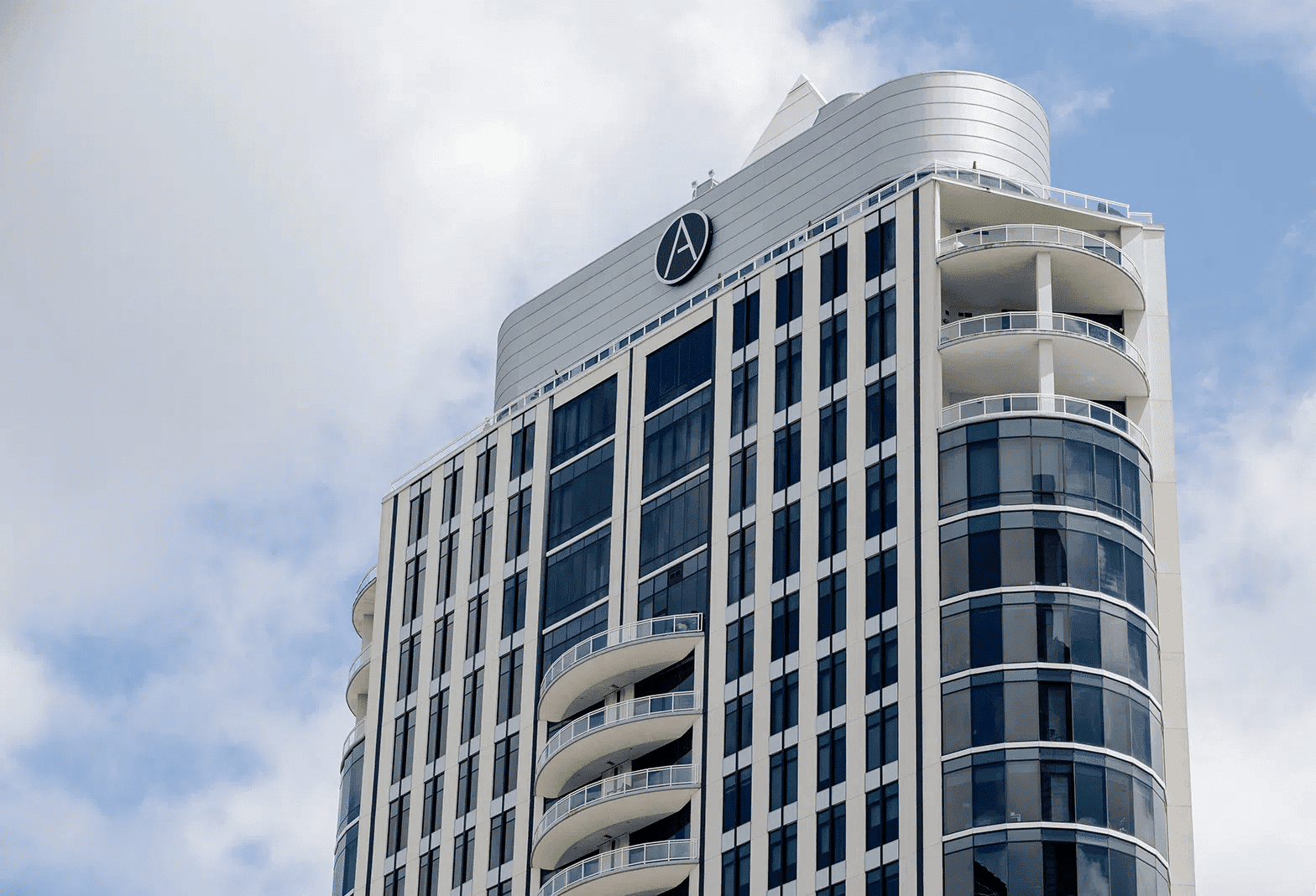 Luxury modern high-rise building in Houston with rooftop balconies, featuring sleek glass facades, representing premium real estate and investment opportunities in Houston EB5 projects.