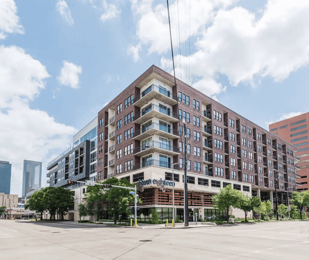 Modern Houston apartment building with eco-friendly design in downtown Houston, TX, showcasing attractive balconies, large windows, and urban living spaces for EB5 investment opportunities.