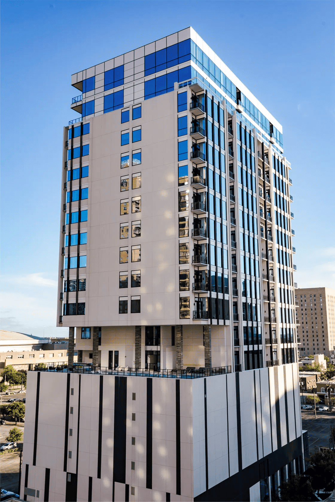 Modern Houston luxury apartment building with extensive glass facades and balconies, featuring contemporary design and prime city location, ideal for EB-5 immigrant investment.