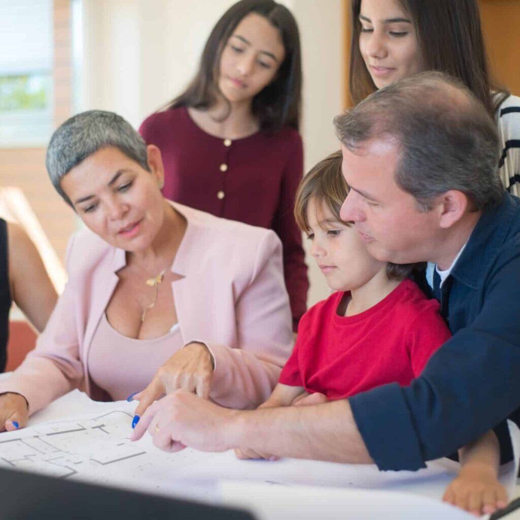 Diverse group of people reviewing an architectural blueprint in a professional setting, emphasizing Houston EB5 investment opportunities and community development.