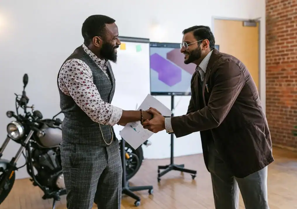 Handshake exchange between two professional men in an office setting, representing Houston EB5 investment opportunities and client relationships.