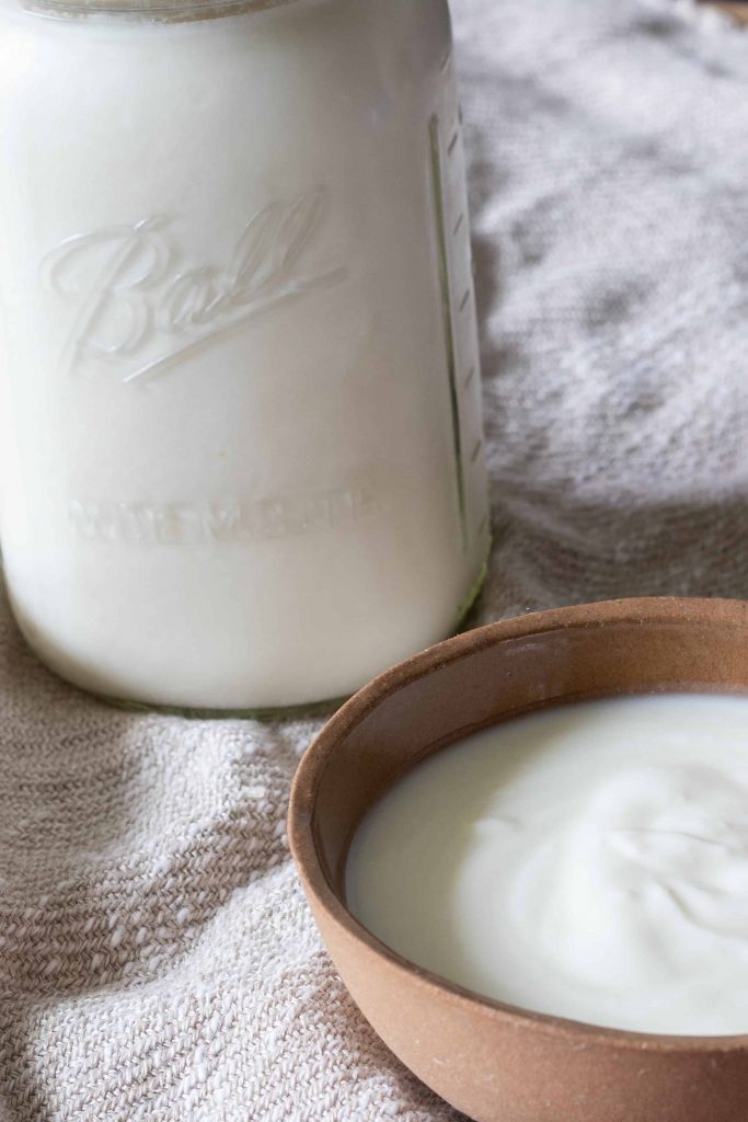 a small bowl and a jar of plain yogurt