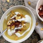 Rutabaga soup with crispy bacon, sour cream, and pumpkin seeds in a bowl.