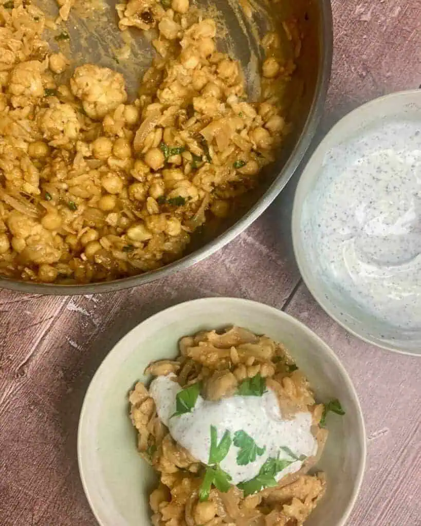 A pan and a bowl of baked orzo with a bowl of yogurt sauce on the side.