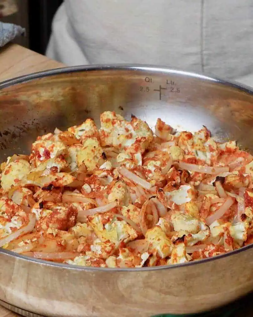 Cauliflower, tossed in tomato paste and spices, roasted in a pan.