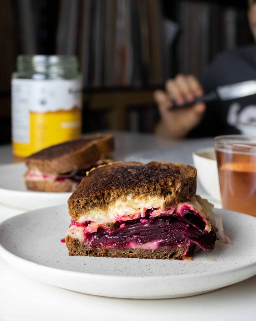 beet sandwich cut in half on a plate.
