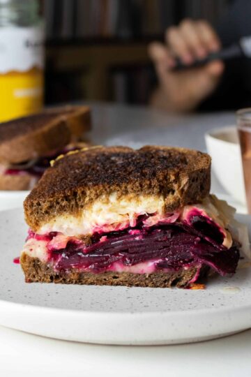 beet sandwich cut in half on a plate.