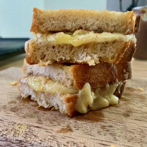 grilled chutney and cheese sandwich on a wooden board.