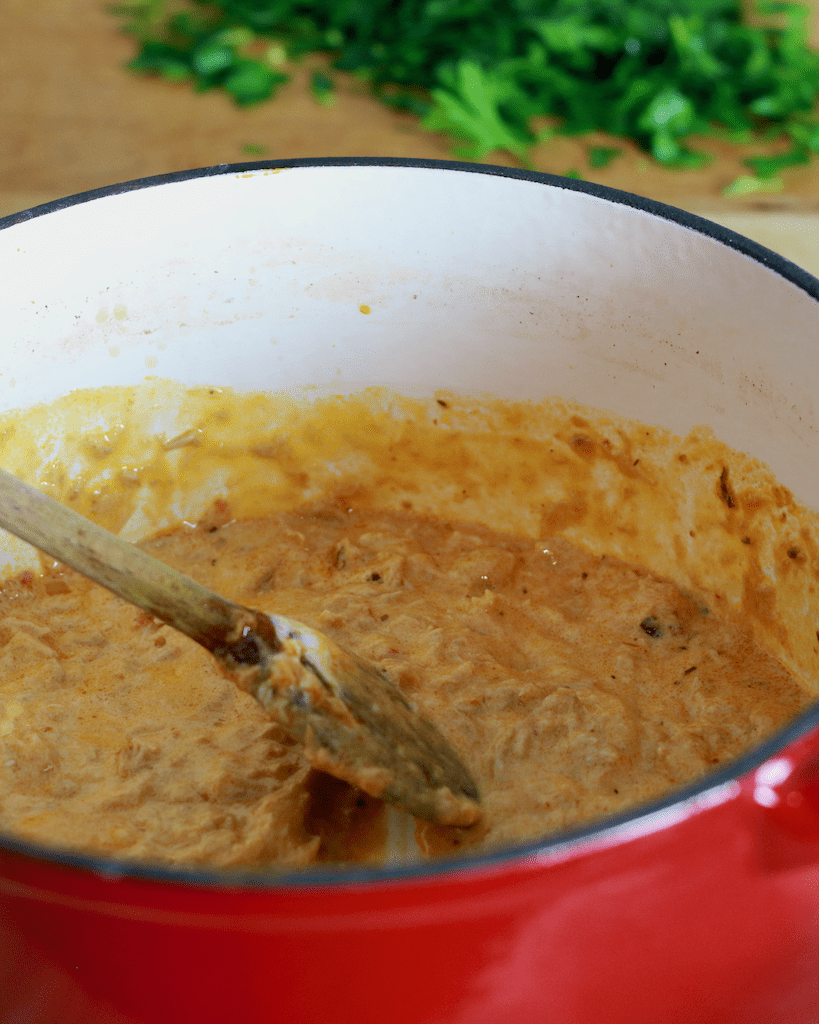 stirring the creamy sauce together.