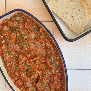 kyopolou and bread in dishes on a tile countertop.