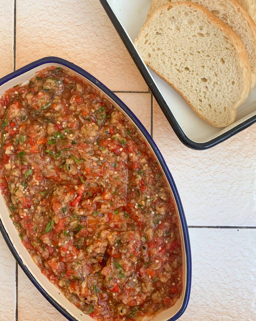 kyopolou and bread in dishes on a tile countertop.
