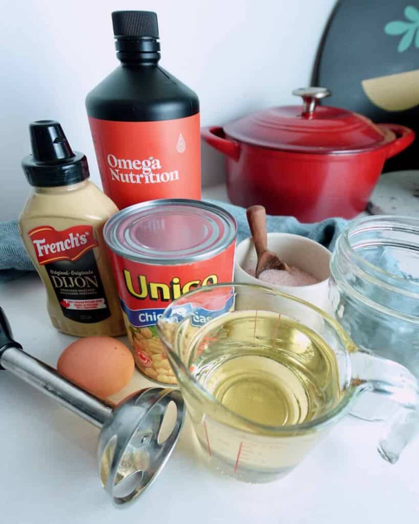 Ingredients and equipment needed to make vegan or regular mayo in a mason jar.