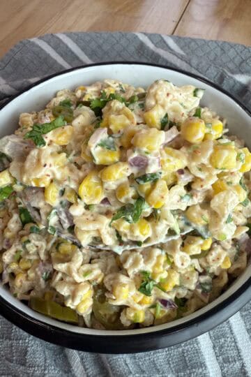 a spoonful of elote pasta salad over a white bowl.