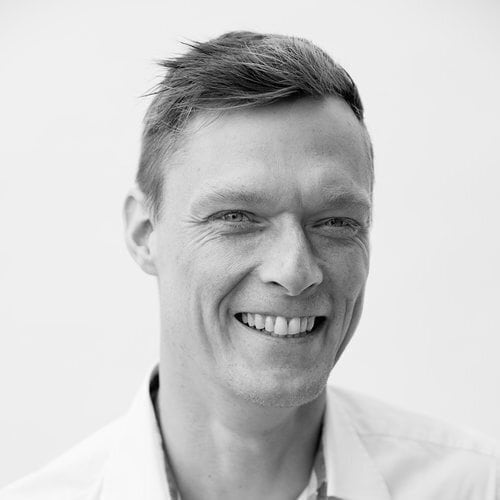 Smilende mand i professionelt foto, repræsenterer Humano konsulentservice og digital transformation.