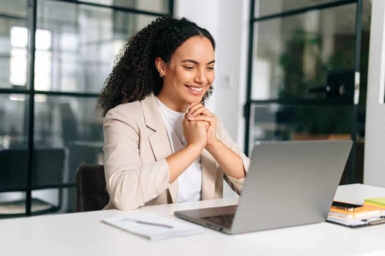 Kvinne i forretningsmøtter ser glad ut på videoanrop.