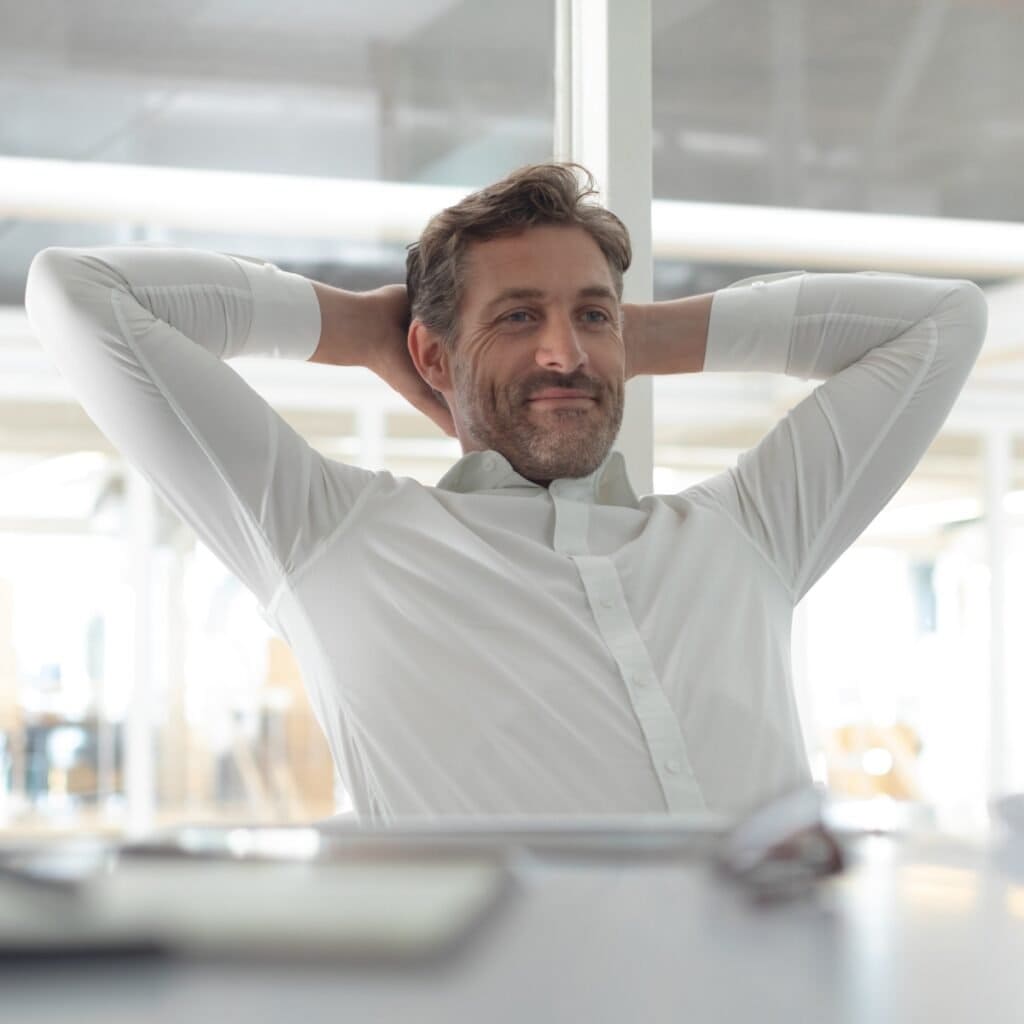 Håndklædt mand i businessmiljø smilende afslappet i kontor.