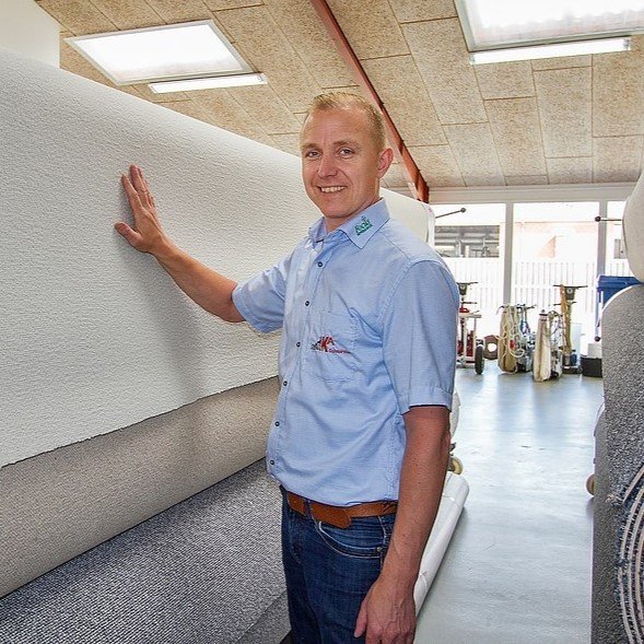 Tekst til ALT: Mand i uniform kontrollerer tapetsetning i showroom.