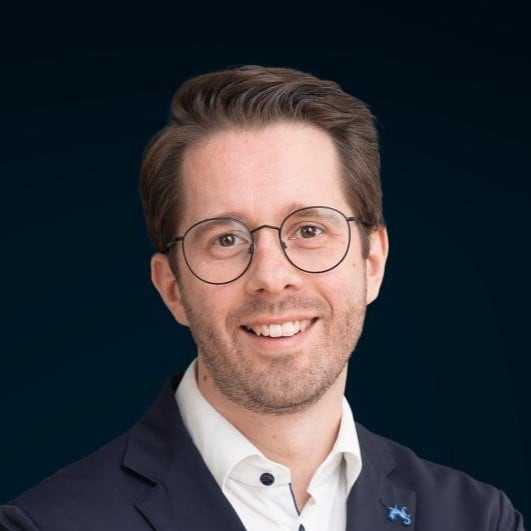 Professionel forretningsmand med glasses, smilende og i formelt tøj til erhvervsfoto.