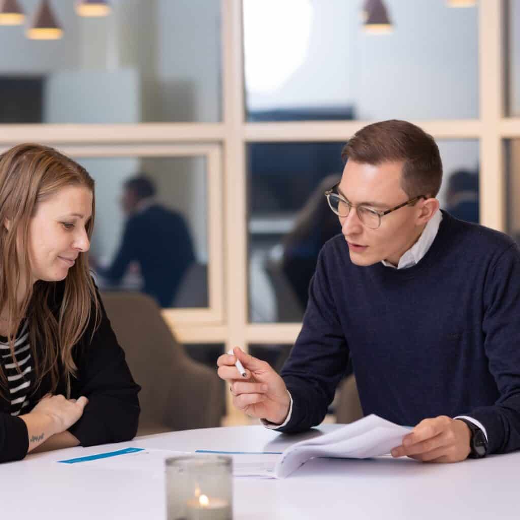 To personer i dialog om konflikthåndtering i et kontormiljø.