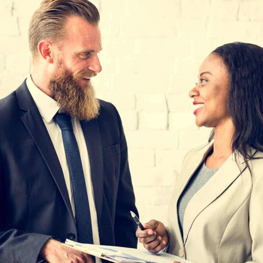 To professionelle personer i samtale under medarbejdermøde.