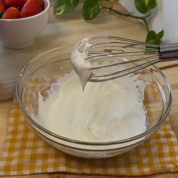 Freshly whipped heavy cream with stiff peaks in a cold bowl, perfect for layering in an easy strawberry tiramisu recipe