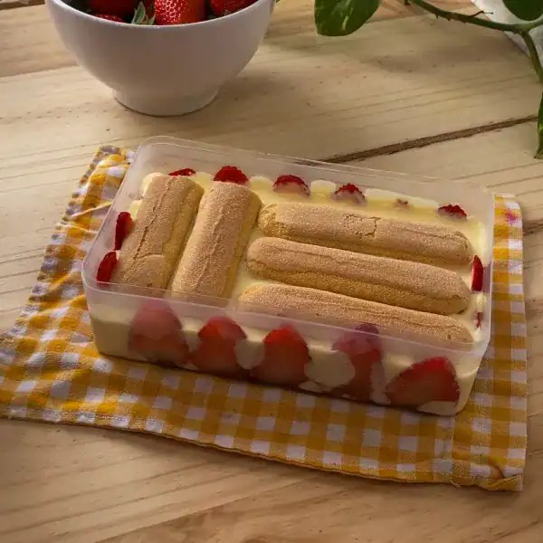 A second layer of ladyfingers being placed over the mascarpone filling in a strawberry tiramisu dessert