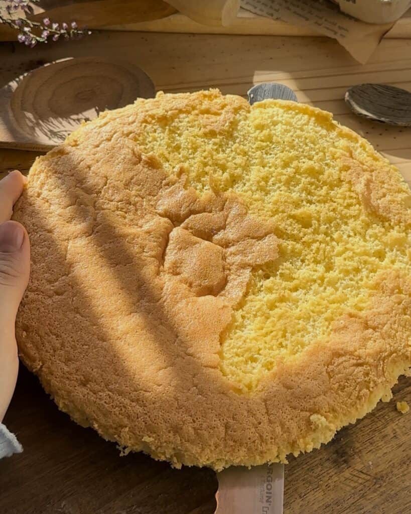 Cutting the freshly baked cake in half, preparing the layers for the homemade raspberry tiramisu