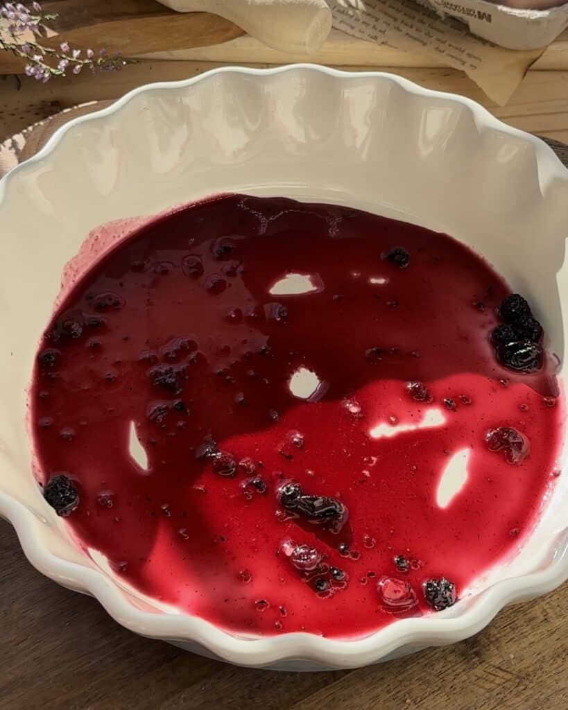 Spreading raspberry jam on the bottom of the baking pan, adding a sweet layer to enhance the flavor of the homemade raspberry tiramisu