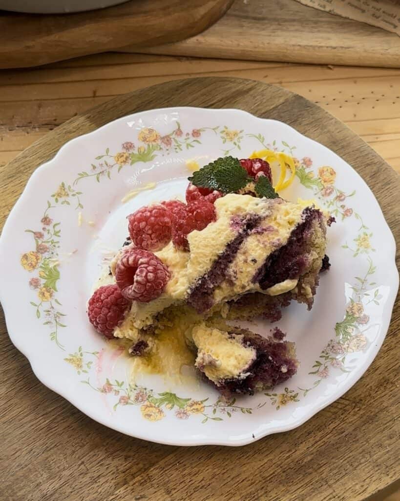 A portion of homemade raspberry tiramisu, layered with fluffy cake, creamy mascarpone, fresh raspberries and sweet raspberry jam, ready to be enjoyed