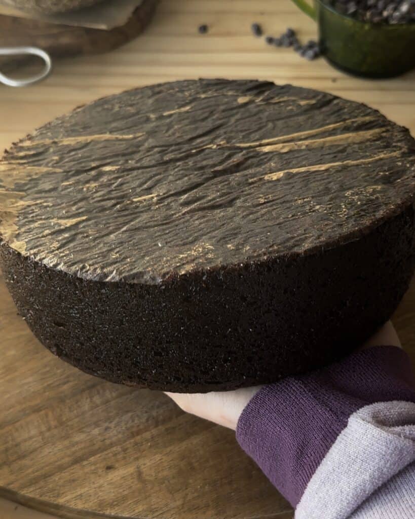 Carefully removing the chocolate cake from the pan and allowing it to cool, ensuring a perfect texture before frosting or serving