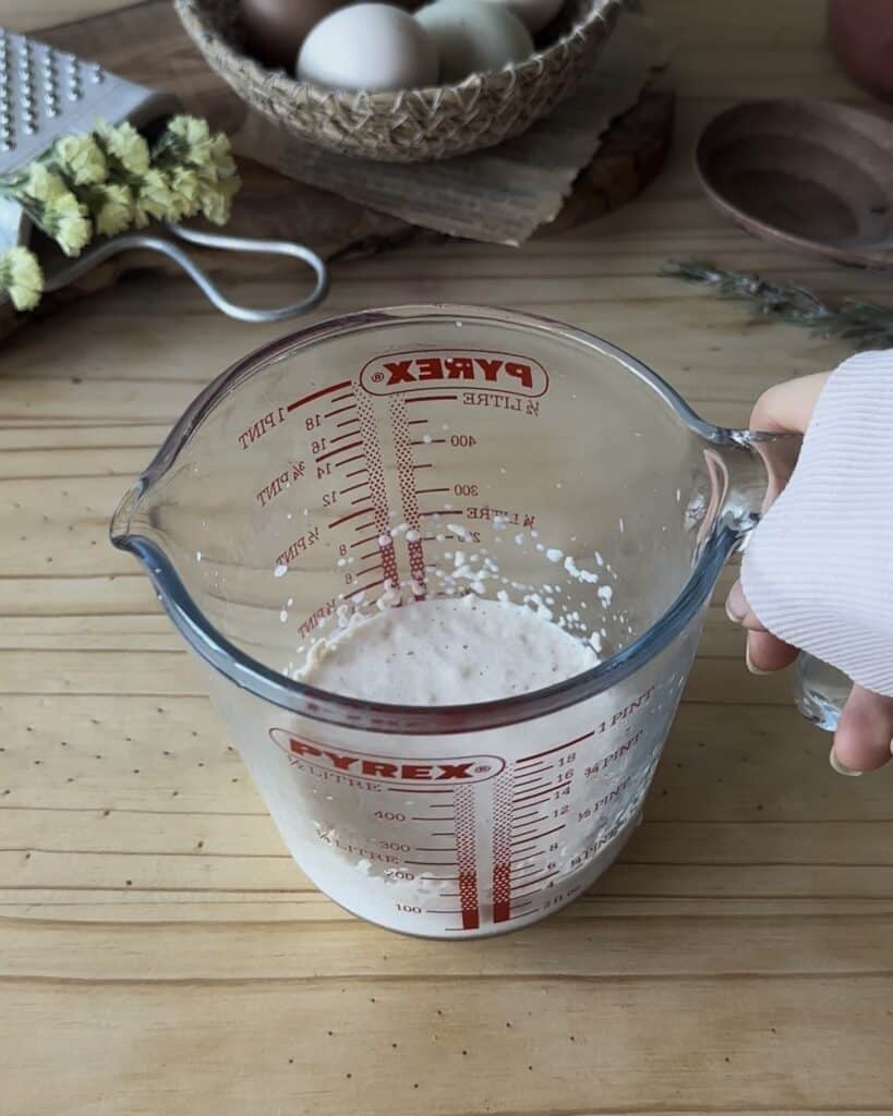 Preparing the sponge for the bunny bread with chocolate, combining sugar, dry yeast, and warm milk to create a bubbly and airy base for the dough