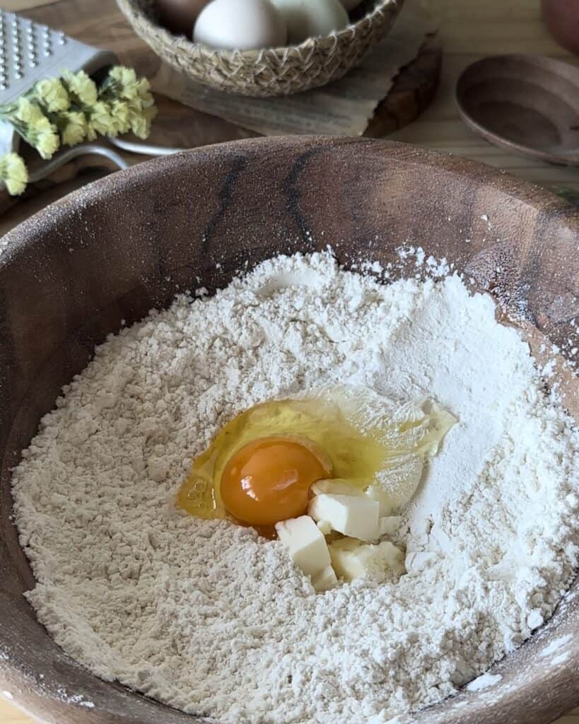 Mixing flour, sugar, butter, egg, salt, and the yeast mixture to create a smooth and rich dough for the bunny bread with chocolate