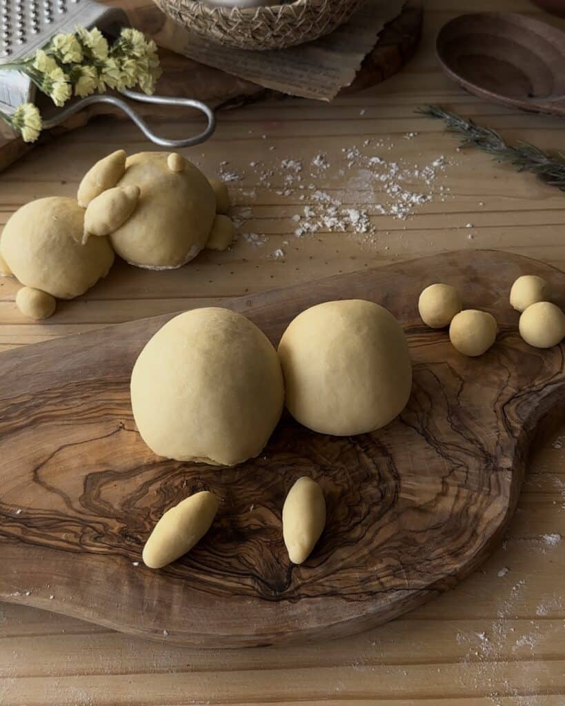 Shaping the dough into a rabbit form, crafting the playful design for the bunny bread