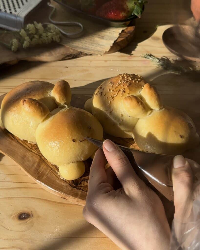 Painting the eyes with melted chocolate on the freshly baked bunny bread, adding a charming finishing touch to the chocolate-filled treat