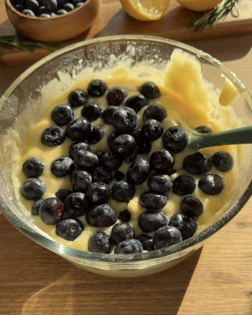 Add fresh blueberries to the batter and gently fold them in to create the perfect bakery-style blueberry lemon muffins