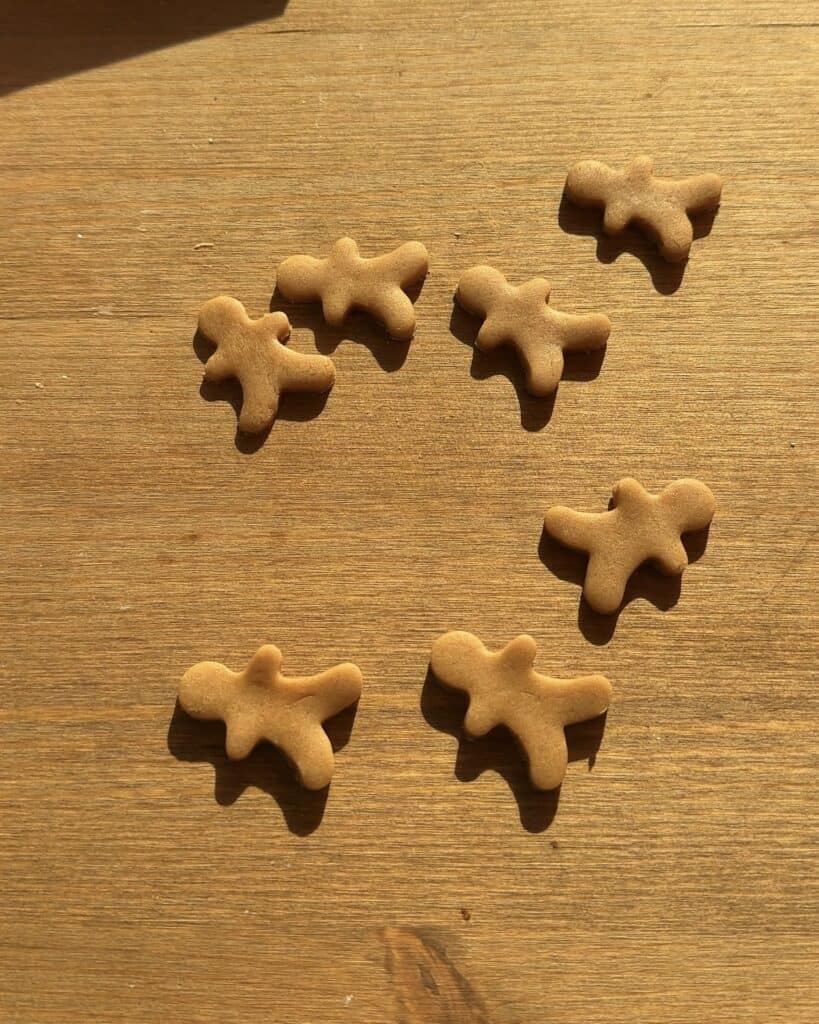 Gingerbread cookies on a wooden table, ready to be used as a festive topping for Christmas brownies, perfect for the holiday season.