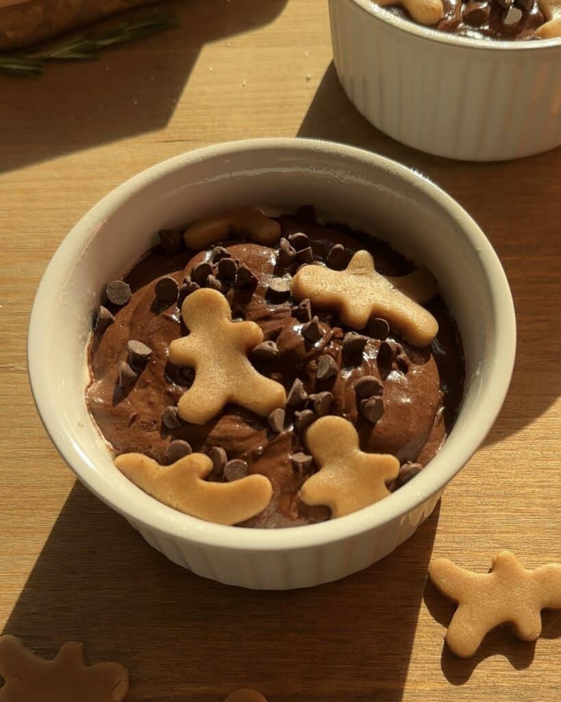 Unbaked Christmas brownies in a baking dish, filled with rich chocolate brownie batter, chocolate drops, and festive gingerbread cookies. Creamy, moist, and full of holiday flavors, these brownies are the perfect Christmas dessert