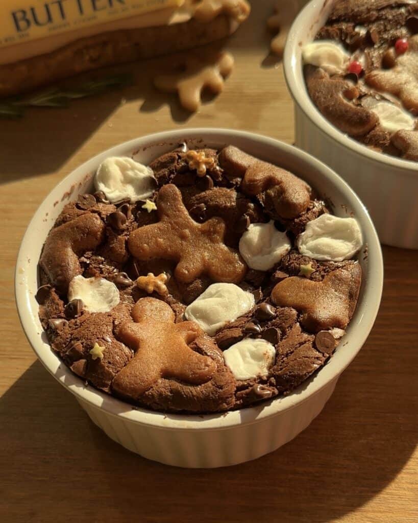 Fluffy and tender Christmas brownies with a rich chocolate base, melted marshmallows, chocolate drops, and topped with festive gingerbread cookies and star sprinkles. Perfect for the holiday season