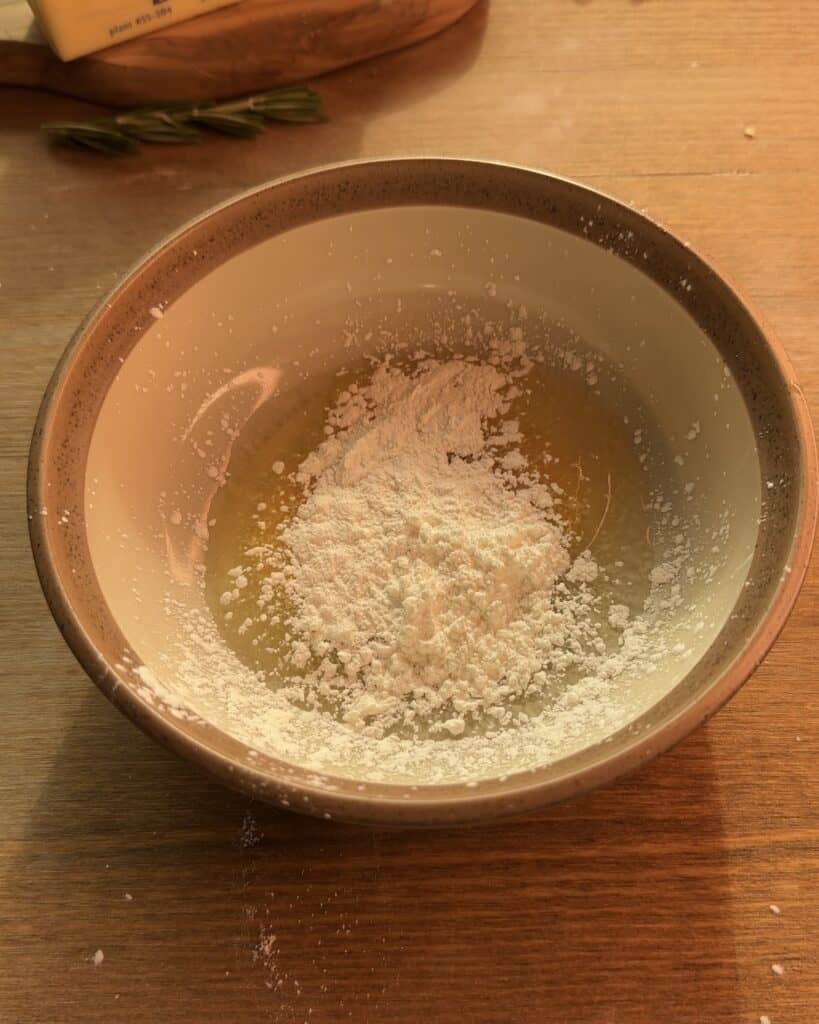 A bowl with cornstarch and egg mixture ready to make the creamy custard for the Gingerbread Apple Pie