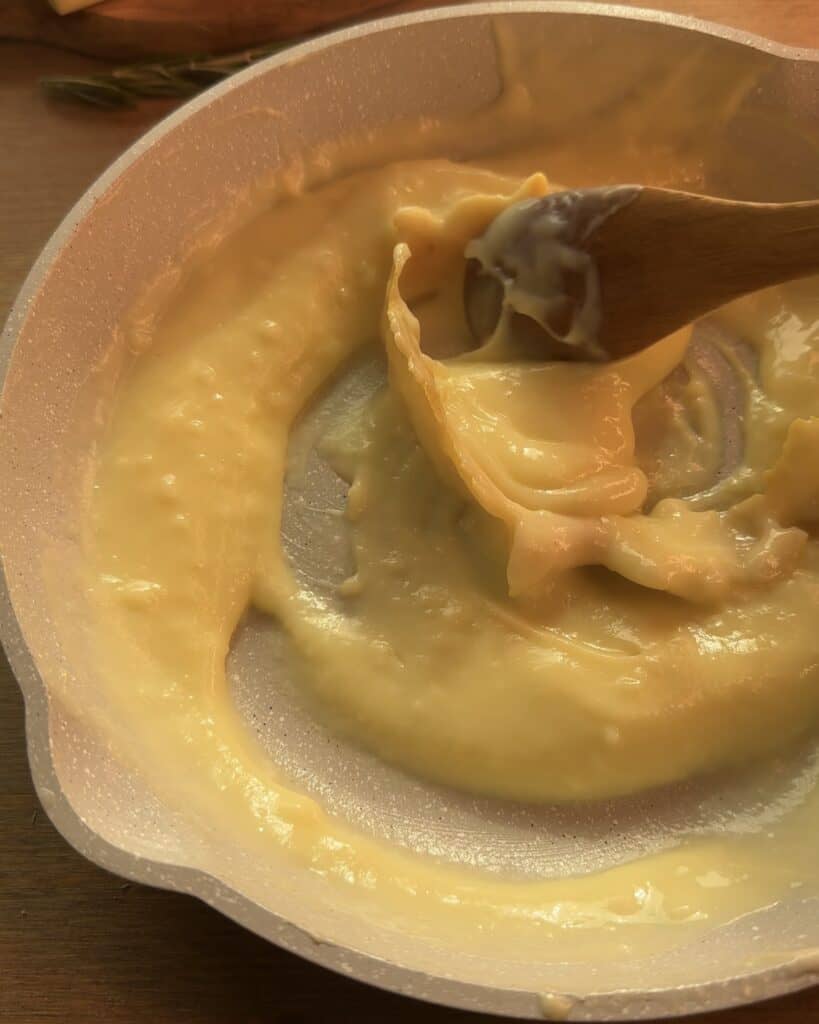 Cooking a rich, velvety custard in a pan with cinnamon and lemon zest for the perfect Gingerbread Apple Pie