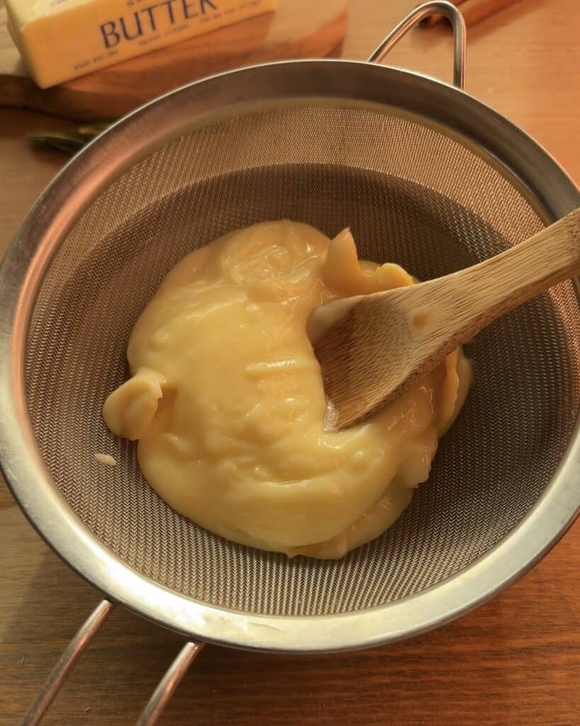 Pass the creamy custard through a fine-mesh strainer to achieve a smooth texture for the Gingerbread Apple Pie