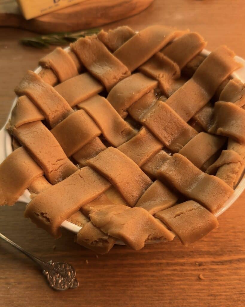 Placing interwoven strips of gingerbread cookie dough on top of the Gingerbread Apple Pie for a beautifully latticed crust.