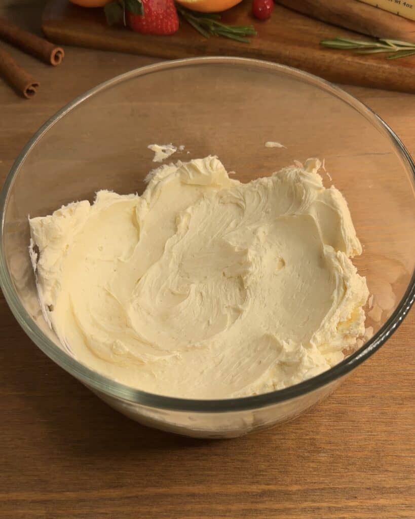 Beaten cream cheese in a bowl, perfectly whipped and creamy, prepared for making Churro cheesecake bars